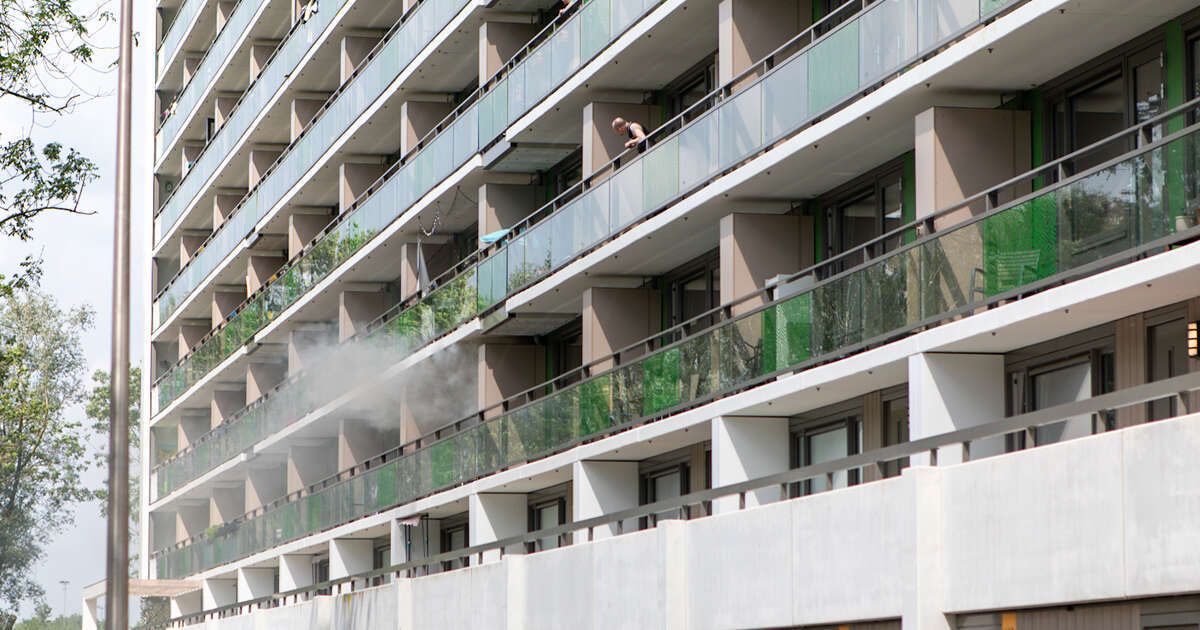 Flinke rookwolken bij brand op balkon van flatwoning in Holtenbroek