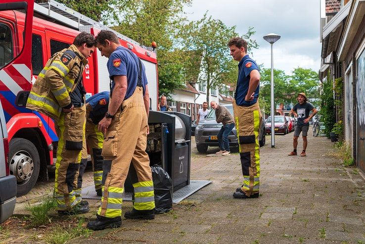 Bewoners Derk Buismanstraat blussen containerbrand - Foto: Peter Denekamp