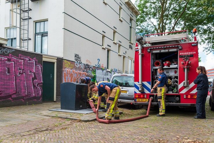 Bewoners Derk Buismanstraat blussen containerbrand - Foto: Peter Denekamp