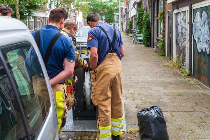 Bewoners Derk Buismanstraat blussen containerbrand - Foto: Peter Denekamp