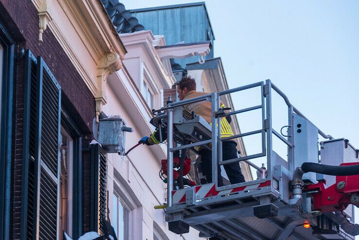 Brandweer verwijdert gevaarlijke ijspegels op Nieuwe Markt - Foto: Peter Denekamp