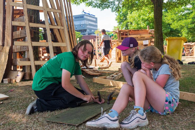 Jennifer Jager helpt de kinderen met het bouwen van een hut. - Foto: Peter Denekamp
