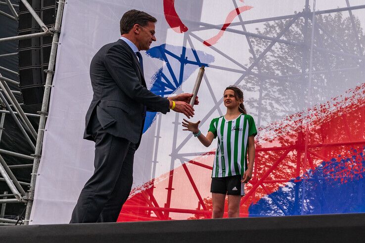 De 12-jarige Roos Plette kreeg de eer om de fakkel aan Mark Rutte te overhandigen. - Foto: Peter Denekamp