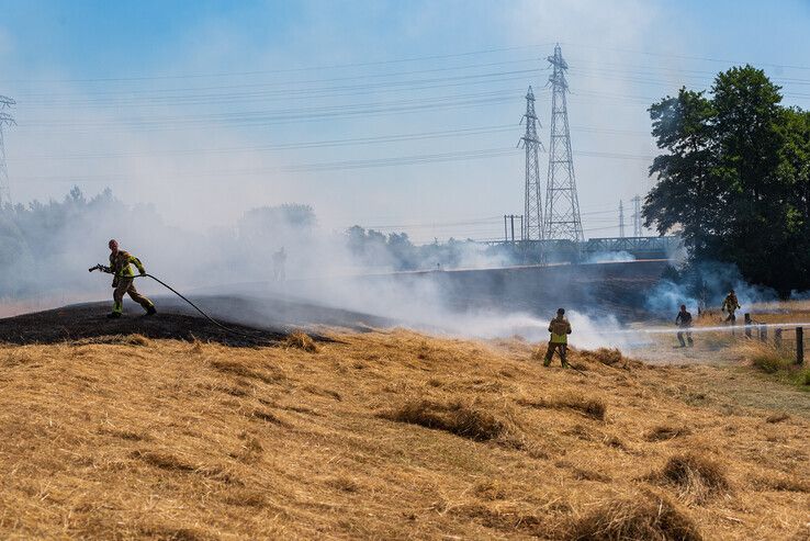 In beeld: Meerdere brandweerkorpsen bestrijden flinke brand op dijk in Zwolle - Foto: Peter Denekamp