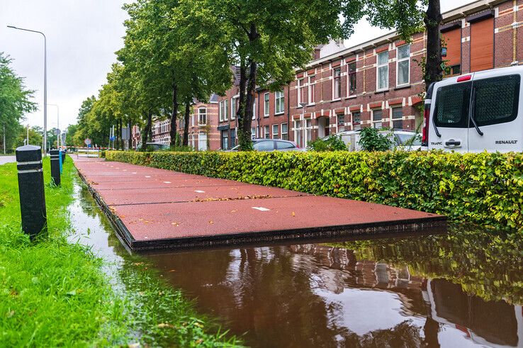 Het plastic fietspad langs de Deventerstraatweg is gaan drijven. - Foto: Peter Denekamp