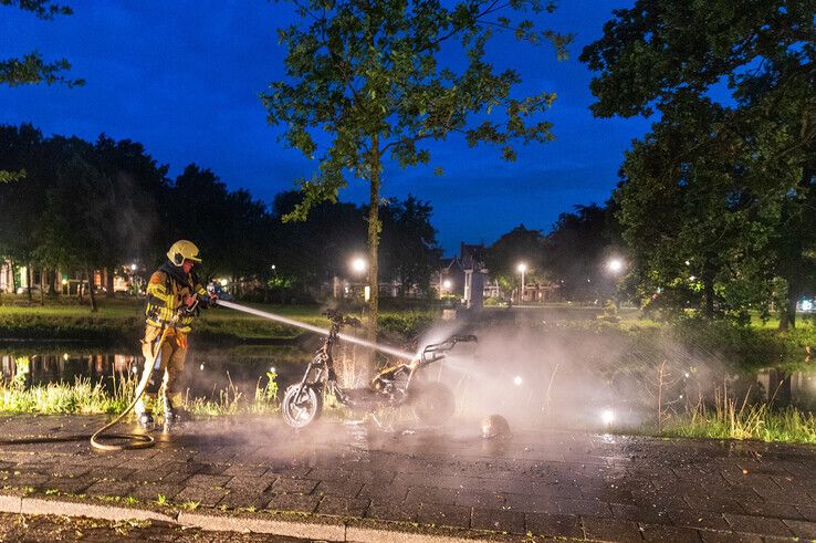 Een deelscooter ging in vlammen op langs de stadsgracht. - Foto: Peter Denekamp