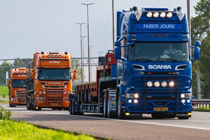 Het konvooi trucks met opleggers van Broshuis uit Kampen trekt over de A28 bij bedrijventerrein Hessenpoort in Zwolle. - Foto: Peter Denekamp