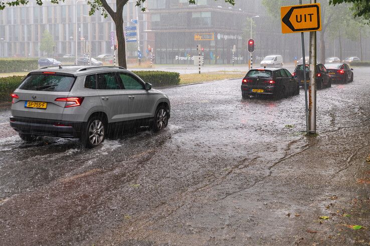 Het water stroomde over de stoepranden heen op de Luttenbergstraat. - Foto: Peter Denekamp