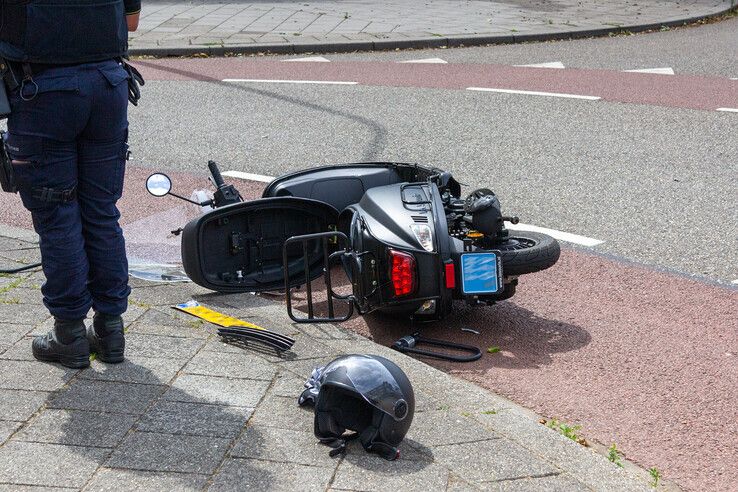 De doorrijder verloor zijn kentekenplaat na de botsing met de scooter. - Foto: Ruben Meinten