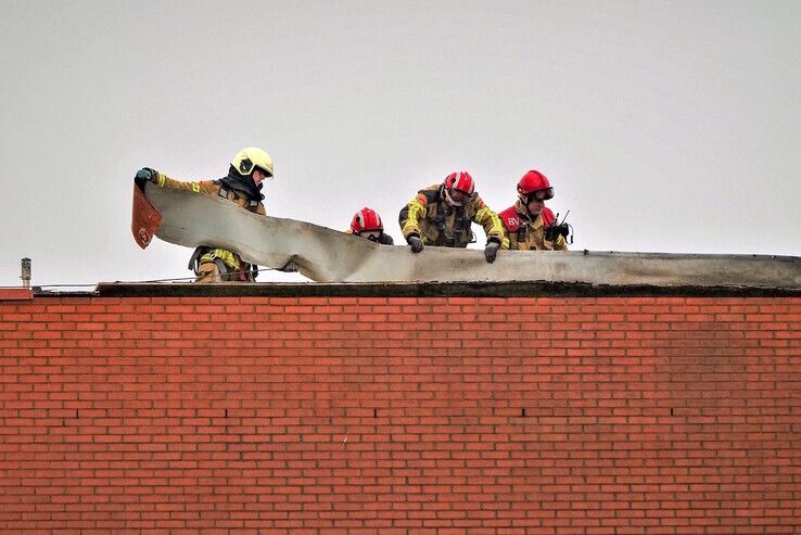 Brandweerlieden verwijderen delen van de losgewaaide dakbedekking. - Foto: Obbe Bakker
