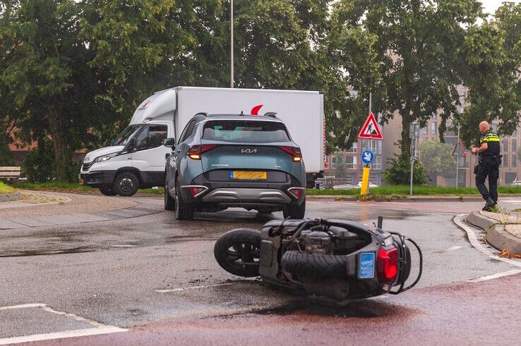 De scooter lekte veel olie en brandstof waardoor de rotonde tijdelijk afgesloten moest worden. - Foto: Peter Denekamp