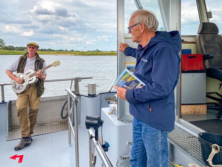 Muzikant Ernst van der Sloot zong met gitaar een liedje over de veerponten voor schipper Teekman. - Foto: Wim Eikelboom