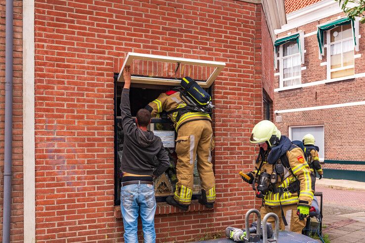 Brandweerlieden probeerden via een raam binnen te komen. - Foto: Peter Denekamp