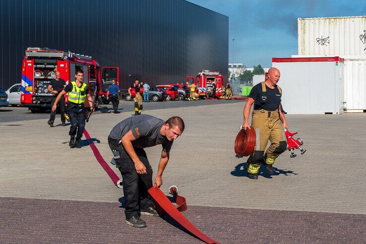 Werknemers van het bedrijf en politieagenten schoten de brandweer te hulp. - Foto: Peter Denekamp