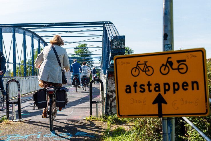 Buiten kantooruren dendert het fietsverkeer over de Hoge Spoorbrug. - Foto: Peter Denekamp