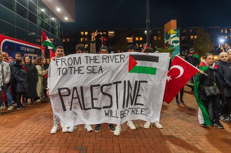 De omstreden leus op een spandoek op het Lübeckplein. - Foto: Peter Denekamp