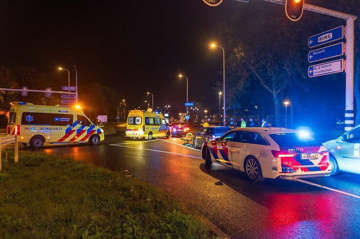 De fietser ligt al in de ambulance, voor de auto liggen de jassen van voorbijgangers die het slachtoffer afdekten. - Foto: Peter Denekamp
