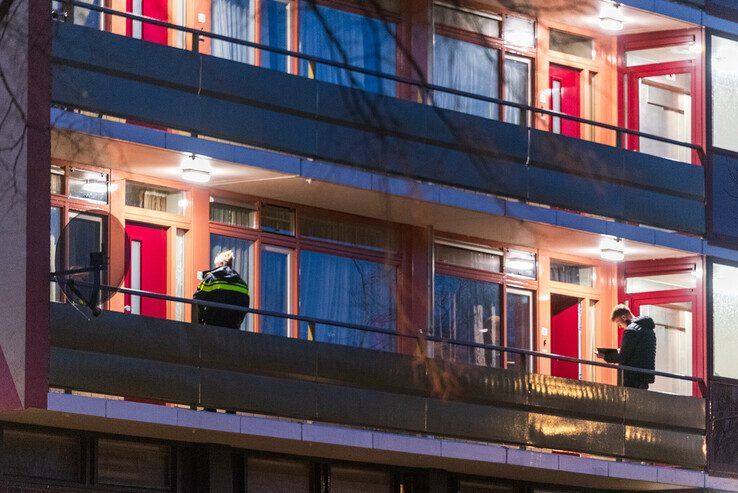 Agenten bezig met het buurtonderzoek in de flat. - Foto: Peter Denekamp