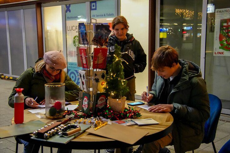 Treinreizigers schrijven een kerstgroet op station Zwolle. - Foto: Obbe Bakker