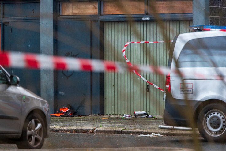 De politie heeft de plaats delict bij de Glenn Millerflat afgezet. Rechts ligt een AED van de politie op de grond. - Foto: Peter Denekamp