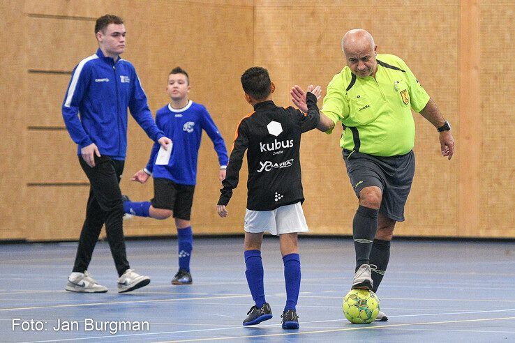 Scheidsrechter Mursel Soner geeft een jonge voetballer een high five. - Foto: Jan Burgman