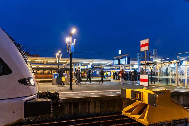 Reizigers uit een net aangekomen trein verlaten snel het perron. - Foto: Peter Denekamp