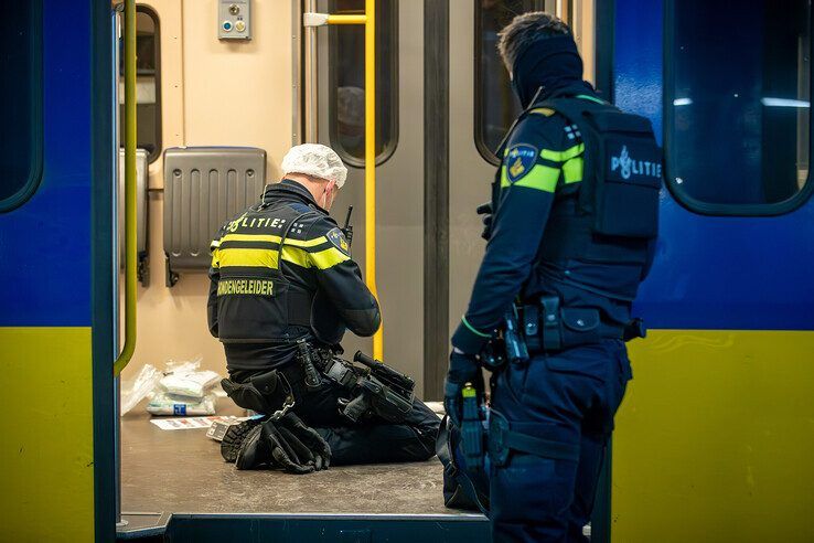 Een politieman bezig met onderzoek in de trein. - Foto: Hugo Janssen