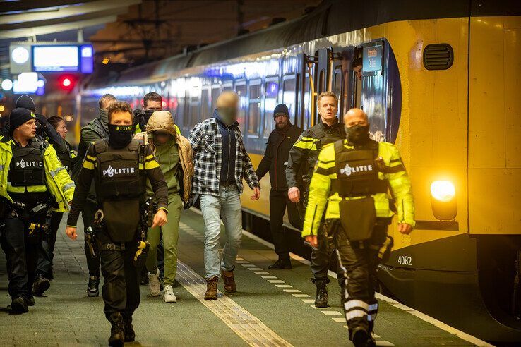 De verdachte man is aangehouden en wordt afgevoerd naar het politiebureau. - Foto: Hugo Janssen