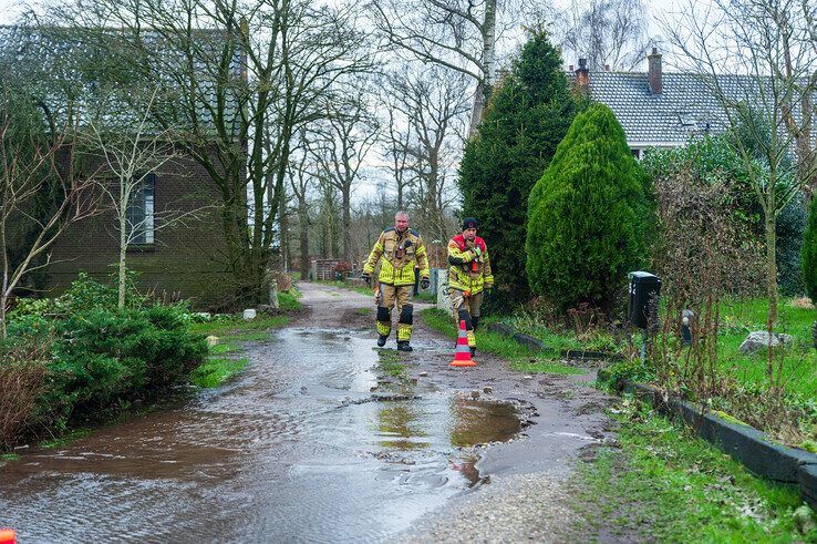 Brandweerlieden bij de lekke waterleiding. - Foto: Peter Denekamp