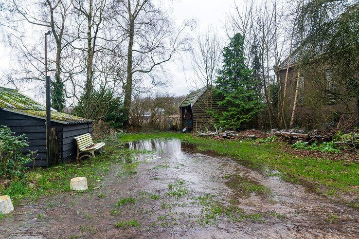 Water stroomt vanuit de lekke waterleiding richting de woningen. - Foto: Peter Denekamp