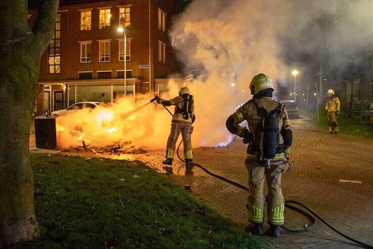 Brandweerlieden blussen een vreugdevuur op het Simon van Slingelandtplein.  - Foto: Ruben Meinten