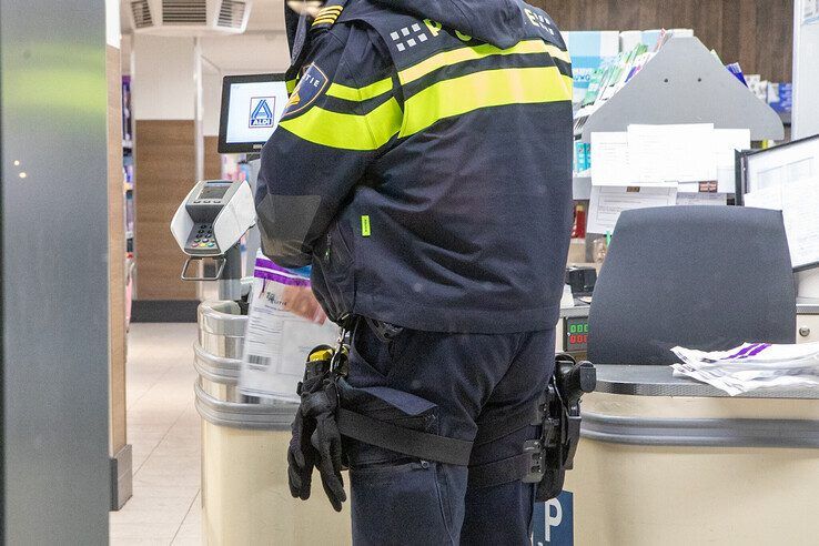 Een politieman stelt een bankbiljet veilig voor sporenonderzoek. - Foto: Ruben Meinten
