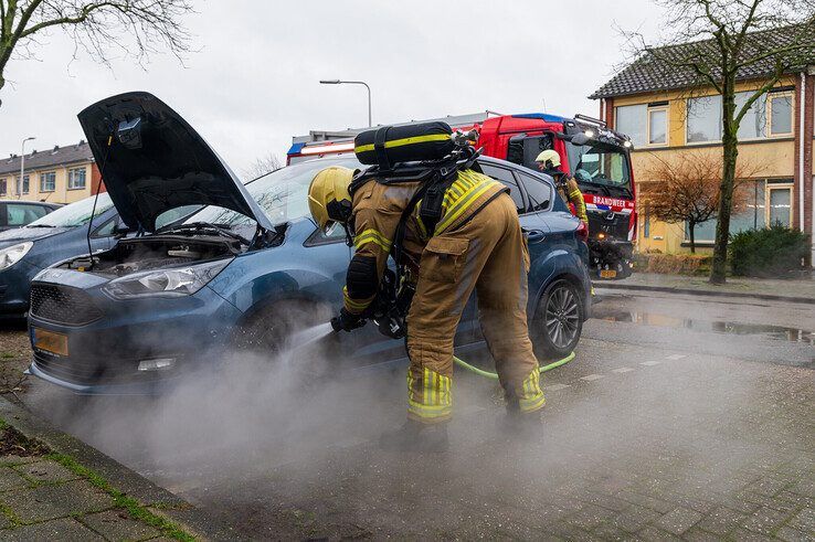 Een brandweerman koelt de oververhitte remschijf. - Foto: Peter Denekamp