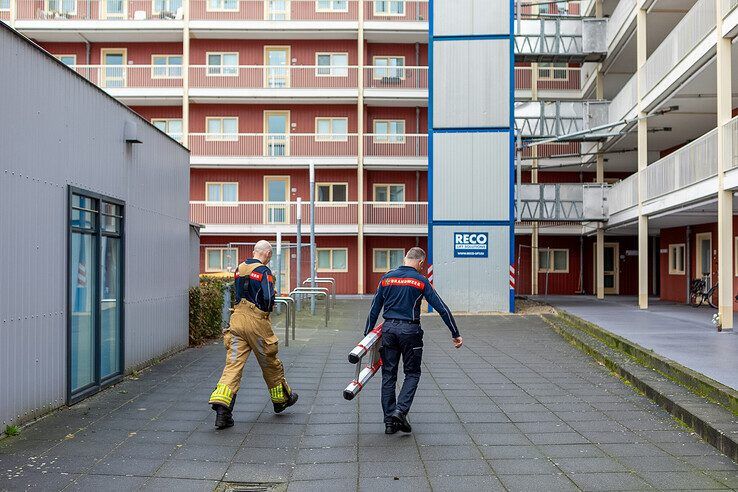 De oudere vrouw werd met een ladder uit de vastgelopen lift gehaald. - Foto: Ruben Meinten