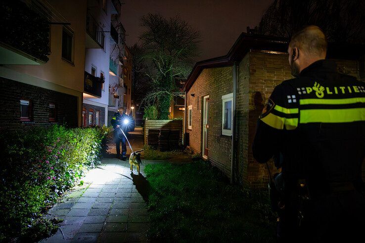 Politieagenten met honden kammen de wijk uit. - Foto: Hugo Janssen