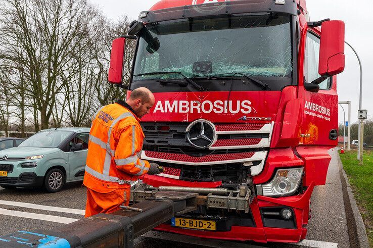Een vrachtwagenberger aan het werk bij de flink beschadigde truck op de IJsselallee. - Foto: Peter Denekamp