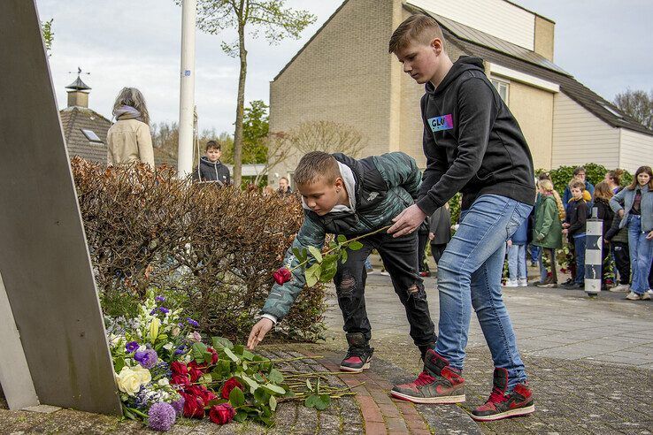 Leerlingen leggen bloemen bij het monument op de Pilotenlaan. - Foto: Obbe Bakker