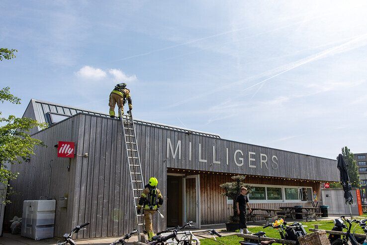 Brandweerlieden voeren een nacontrole uit op het dak van Milligers. - Foto: Ruben Meinten