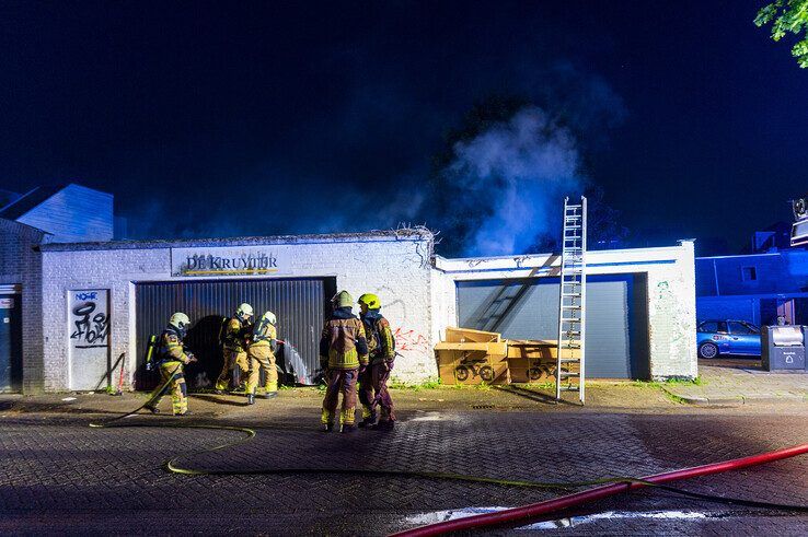 Brandweerlieden forceren de garagedeur op 't Streekien. - Foto: Peter Denekamp