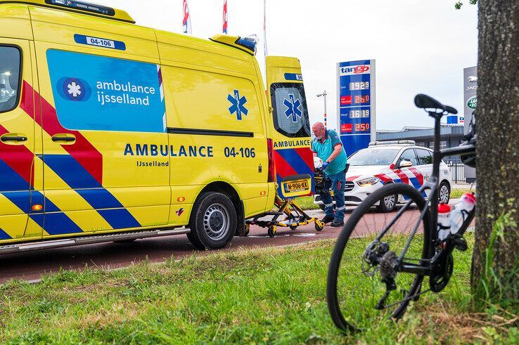 De wielrenner wordt per ambulance naar het ziekenhuis gebracht. - Foto: Peter Denekamp