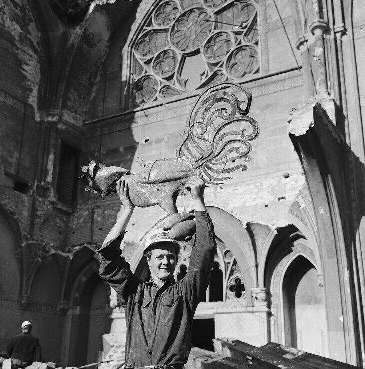 Een sloper houdt de haan trots omhoog. - Foto: Collectie Overijssel/Dolf Henneke