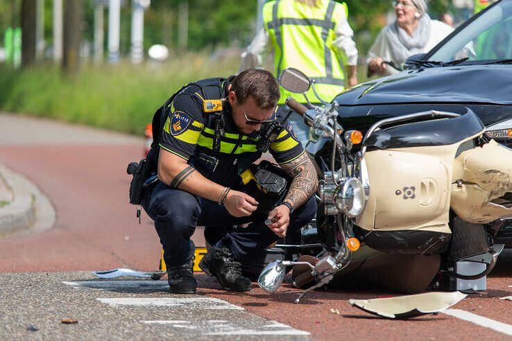 Een politieman bekijkt de schade na de botsing op de Blaloweg. - Foto: Ruben Meinten