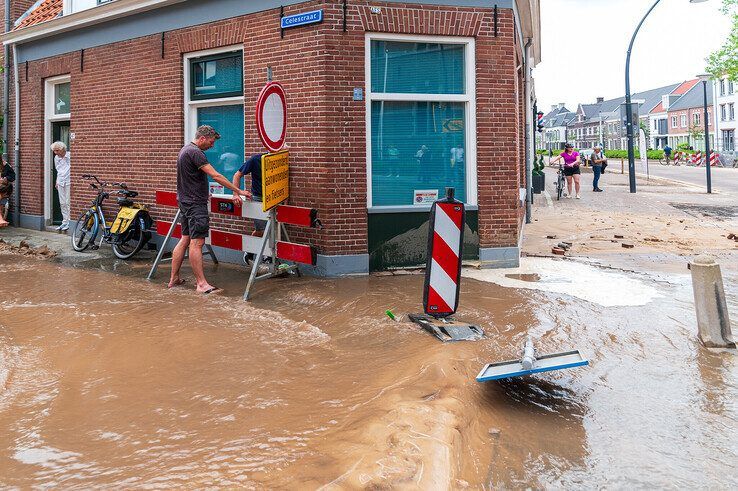 Water en zand spoelt onder de woning aan de Celestraat vandaan door de leidingbreuk. - Foto: Peter Denekamp