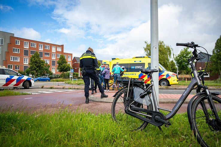 Hulpverleners ontfermen zich over de aangereden fietsster op de rotonde. - Foto: Hugo Janssen