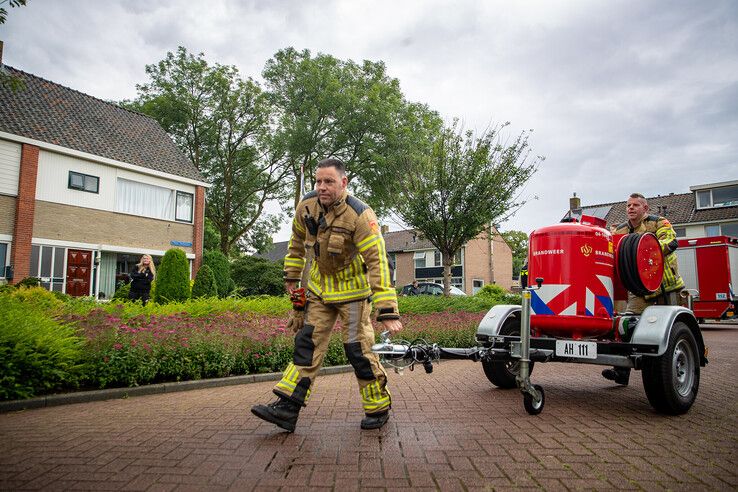 Brandweerlieden met de poederblusaanhanger in Berkum. - Foto: Hugo Janssen