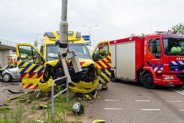 De ambulance ramde na de botsing een verkeerspaal. - Foto: Peter Denekamp