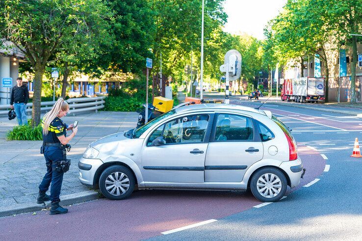 Een agente maakt foto's na het ongeval. - Foto: Peter Denekamp