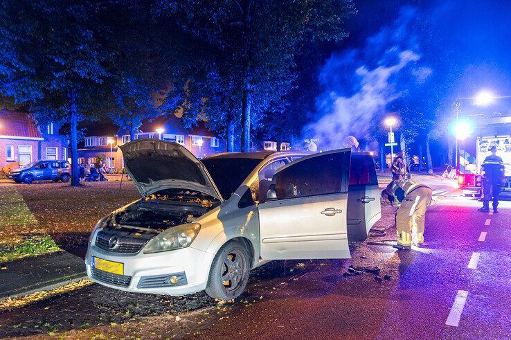 Brandweerlieden blussen de autobrand op de Hanekamp. - Foto: Peter Denekamp