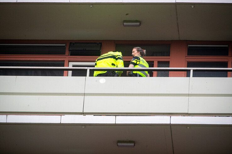 Politieagenten bij de woning op de achtste etage. - Foto: Hugo Janssen