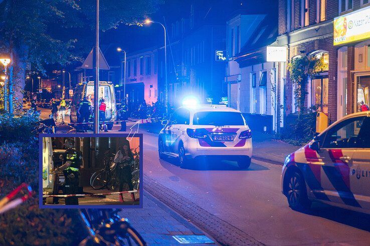 De vrouw met rode schoenen staat 20 minuten na de liquidatiepoging naast de ambulance. - Foto: Peter Denekamp